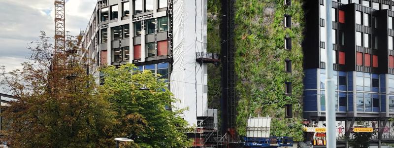 Vy som möter besökare som kommer in till Oslo med tåg. Det 35 meter höga trapphuset med Europas högsta växtvägg.