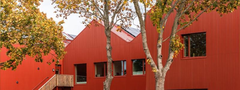 Röd plåt dominerar exteriört byggmaterialet i Mörrums nya F-6 skola med en arkitektur med fokus på hållbarhet och små volymer. Bild: Fojab arkitekter