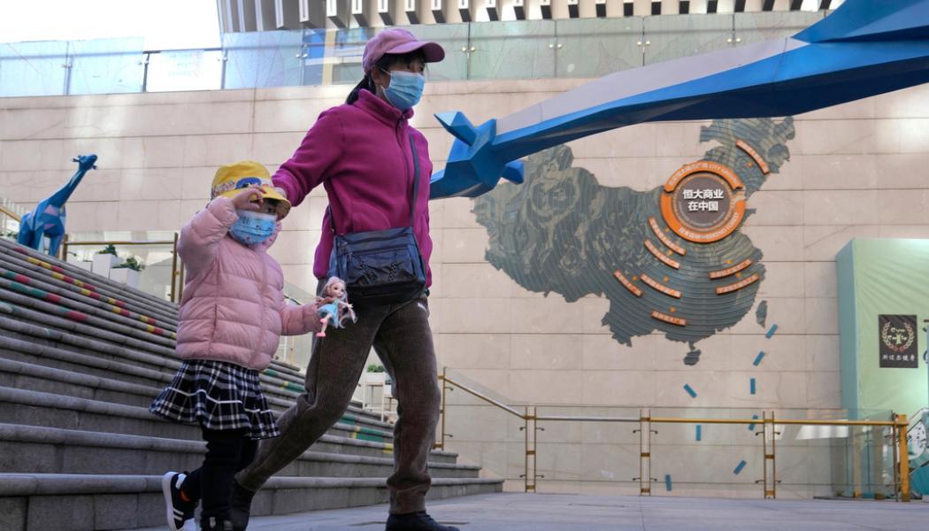 Ng Han Guan/AP/TT: En kinesisk familj passerar ett av fastighetsjätten Evergrandes många bostadsprojekt i Kina. Arkivbild.