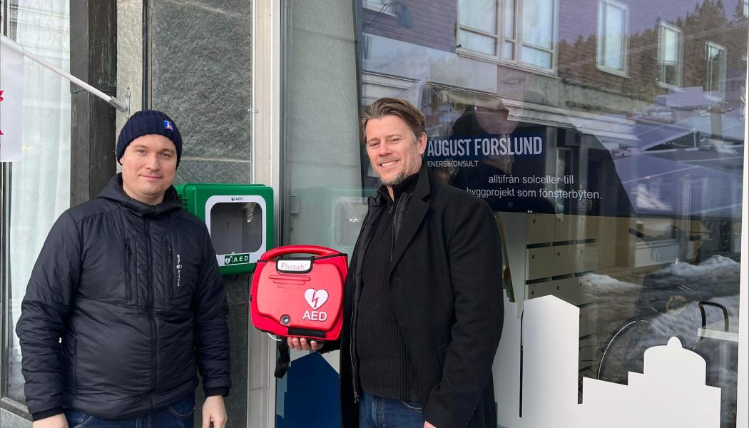 Willy Runnzell, affärsområdeschef på HSB Södra Norrland och Christer Karlsson på Plusab Medical Solution vid hjärtstartaren utanför HSBs kontor i Östersund. Foto: HSB Södra Norrland 