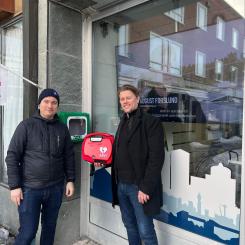 Willy Runnzell, affärsområdeschef på HSB Södra Norrland och Christer Karlsson på Plusab Medical Solution vid hjärtstartaren utanför HSBs kontor i Östersund. Foto: HSB Södra Norrland