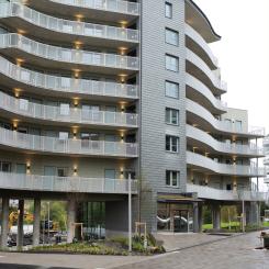 En grå vågformad byggnad med loftgångar. Vågkanten, Partille 2024. Av: Julia Sjöberg
Upphovsrätt: Wikström Installationskonsult AB